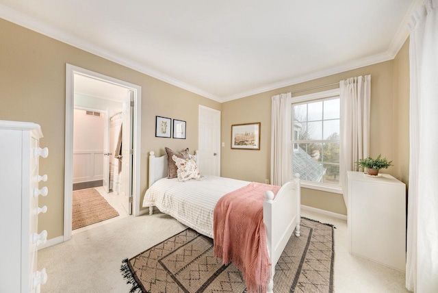 carpeted bedroom with connected bathroom, visible vents, crown molding, and baseboards