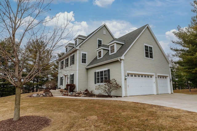 view of front of house featuring a front lawn, driveway, a shingled roof, and an attached garage