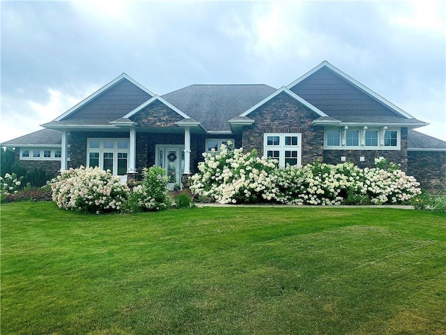 craftsman-style home with stone siding and a front yard