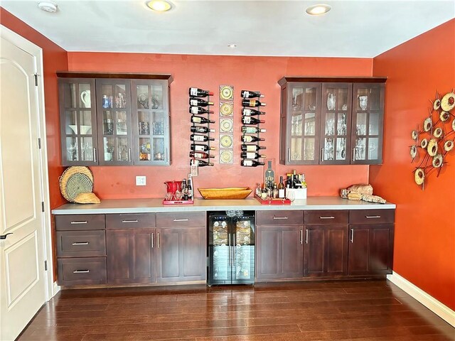 1747 E Drinkman Ln, Eau Claire, WI 54701 - bar featuring a bar, dark wood finished floors, baseboards, and beverage cooler