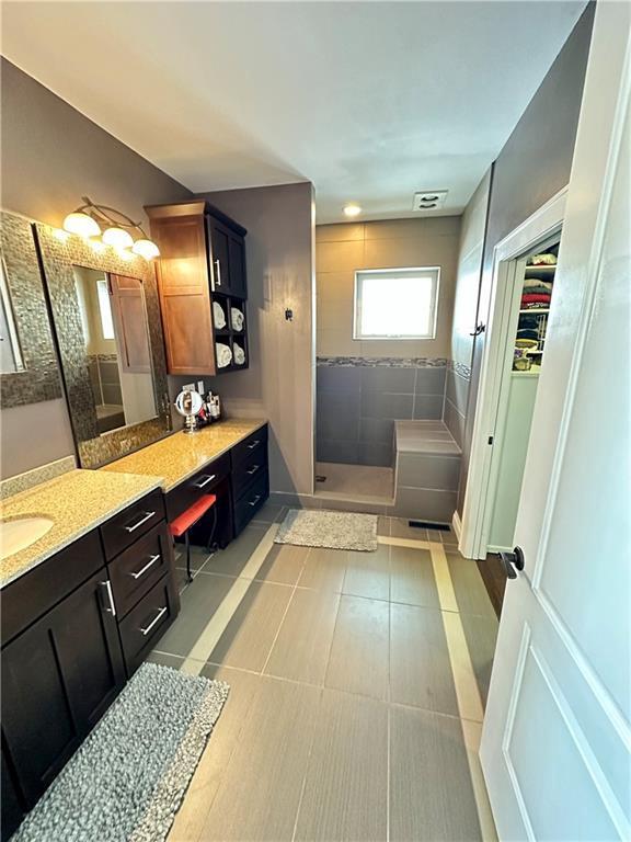 1747 E Drinkman Ln, Eau Claire, WI 54701 - full bath with vanity, baseboards, a spacious closet, tile patterned floors, and walk in shower
