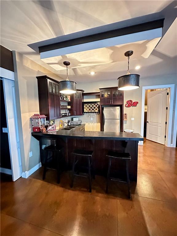1747 E Drinkman Ln, Eau Claire, WI 54701 - bar featuring a sink, pendant lighting, freestanding refrigerator, and baseboards