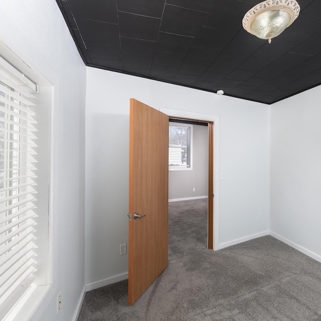 spare room featuring carpet and baseboards