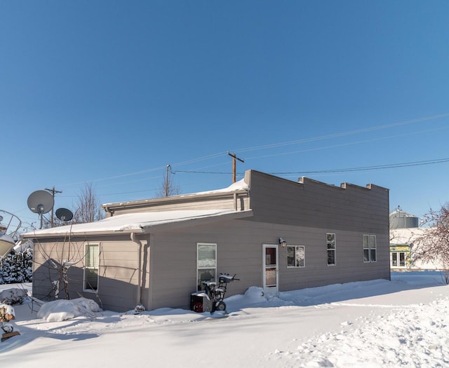 view of snow covered rear of property