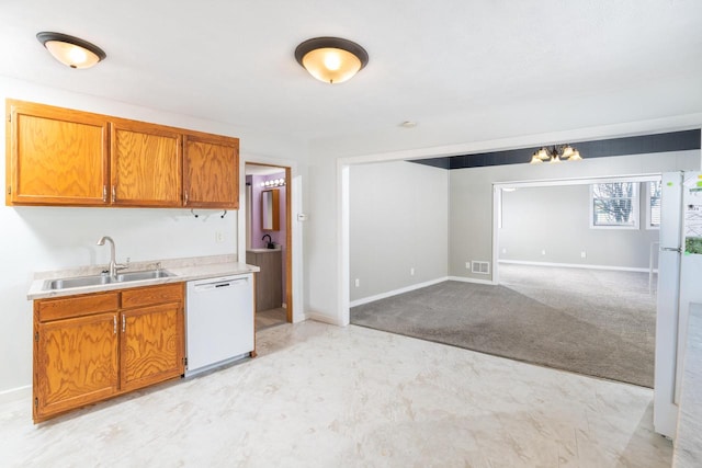 kitchen with light countertops, visible vents, brown cabinetry, a sink, and dishwasher