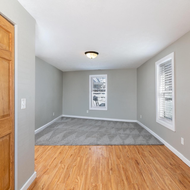 spare room with light wood-style flooring and baseboards