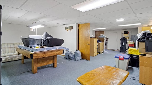 recreation room with carpet and a paneled ceiling