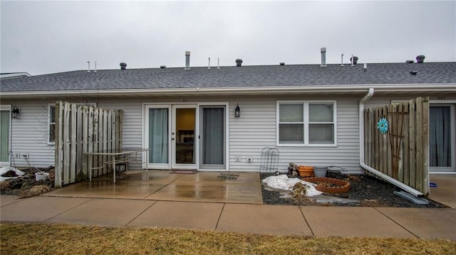 back of house with a patio area, a shingled roof, and fence