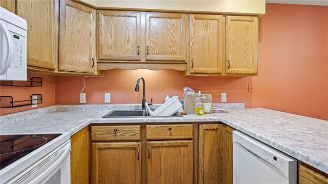 kitchen with white appliances, light countertops, and a sink