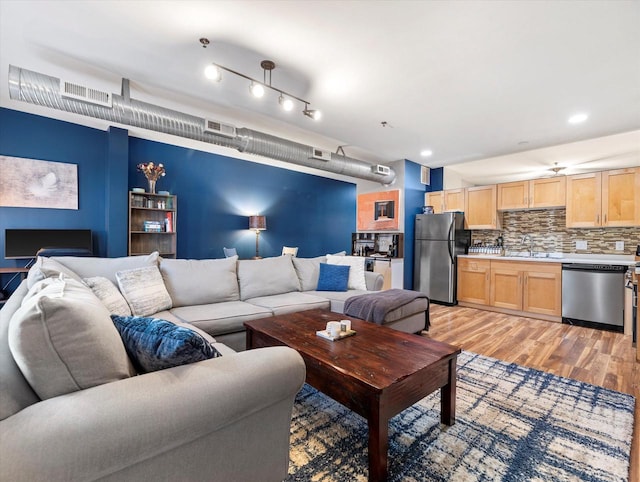 living area featuring light wood-style floors and visible vents