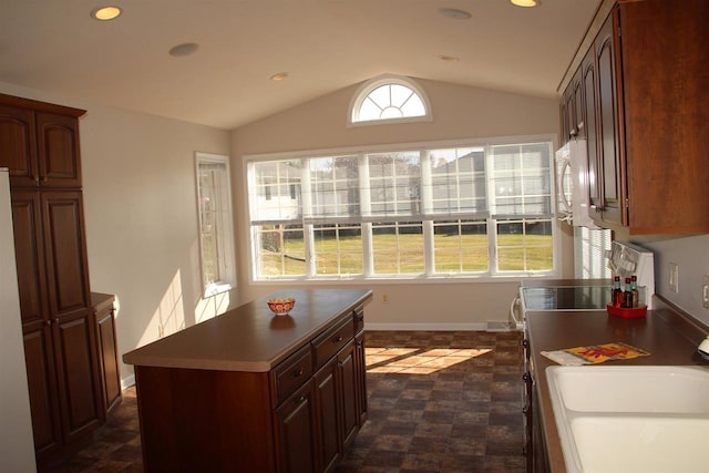 kitchen with lofted ceiling, a sink, and recessed lighting