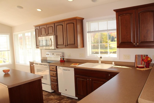 kitchen featuring white appliances, light countertops, a sink, and recessed lighting