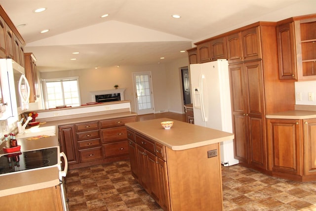 kitchen with vaulted ceiling, white appliances, light countertops, and a sink