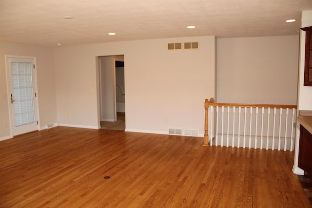 unfurnished room with recessed lighting, visible vents, baseboards, and wood finished floors