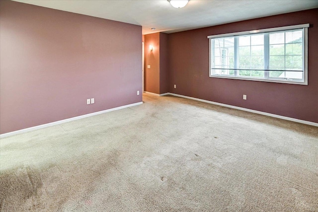 unfurnished room featuring carpet flooring and baseboards