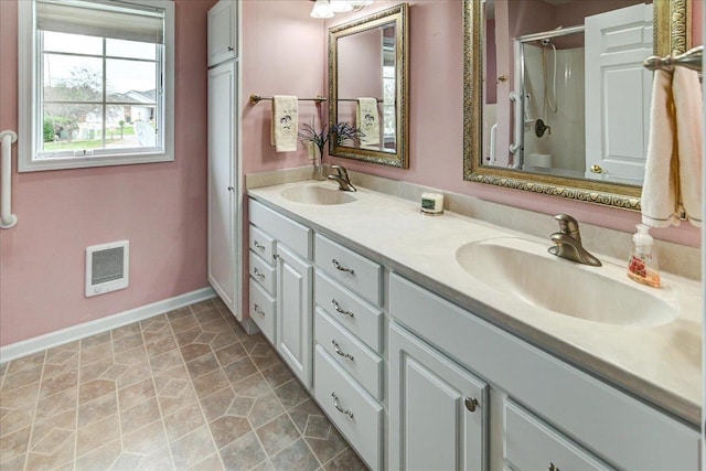 full bath featuring double vanity, an enclosed shower, a sink, and visible vents