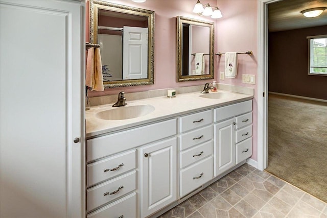 bathroom with a sink, baseboards, and double vanity