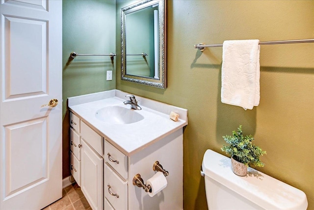 half bathroom with toilet, tile patterned floors, and vanity