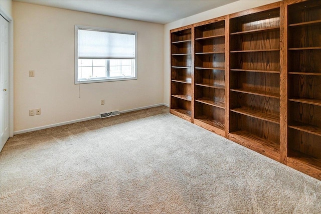 carpeted empty room with visible vents and baseboards