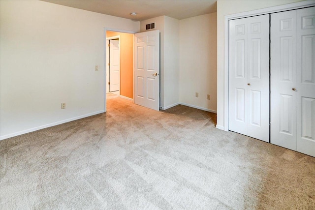 unfurnished bedroom with a closet, visible vents, baseboards, and carpet flooring