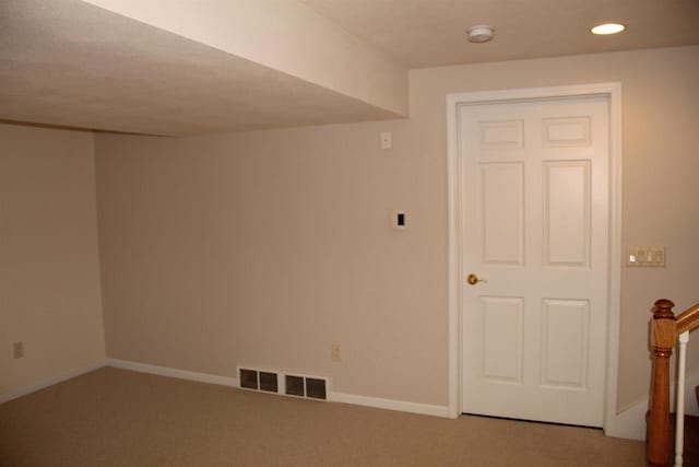 carpeted spare room featuring recessed lighting, visible vents, baseboards, and stairs