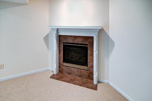 room details with a tiled fireplace, carpet flooring, and baseboards