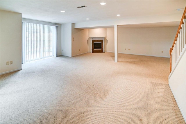 below grade area featuring stairs, a fireplace, visible vents, and baseboards