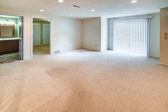 unfurnished room featuring carpet floors, visible vents, and recessed lighting