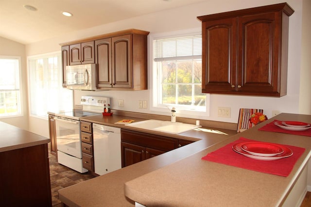 kitchen featuring white appliances, a sink, and recessed lighting