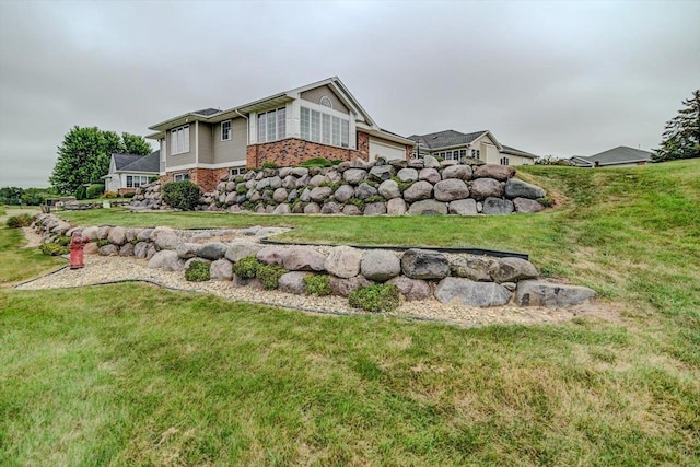 view of home's exterior featuring a garage, a lawn, and brick siding