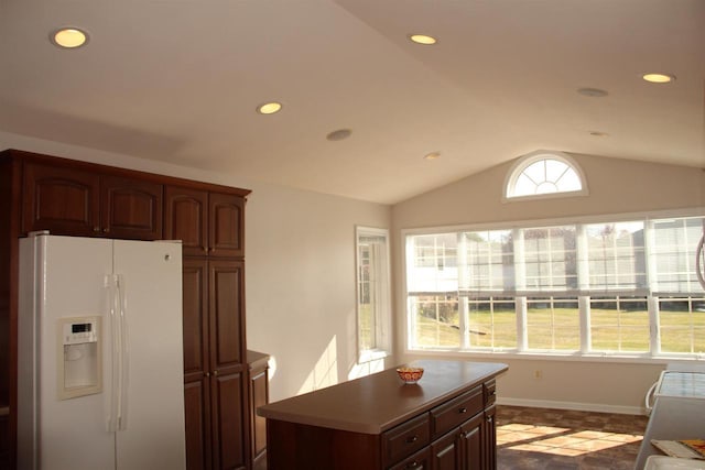 kitchen with a wealth of natural light, white refrigerator with ice dispenser, lofted ceiling, and recessed lighting