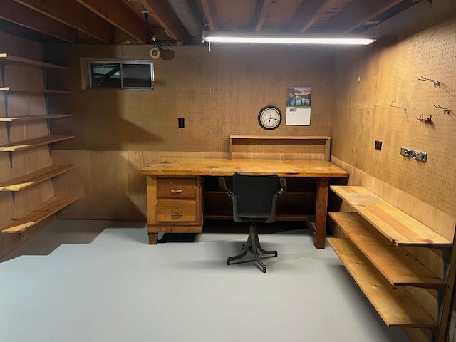 home office with finished concrete flooring and a workshop area