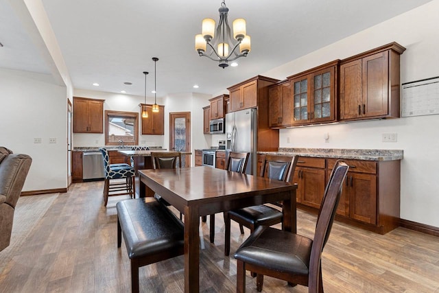 dining room with light wood-style floors, baseboards, an inviting chandelier, and recessed lighting