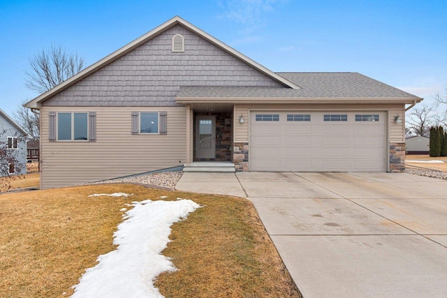 view of front of house featuring a garage, concrete driveway, roof with shingles, and stone siding