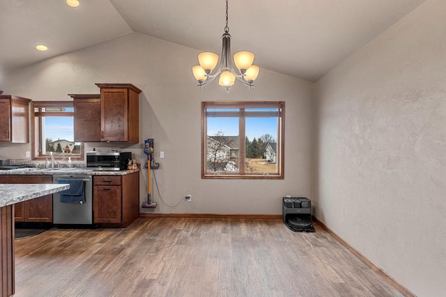 kitchen with pendant lighting, stainless steel appliances, vaulted ceiling, wood finished floors, and baseboards