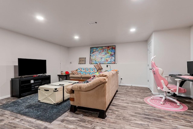 living area with baseboards, wood finished floors, visible vents, and recessed lighting