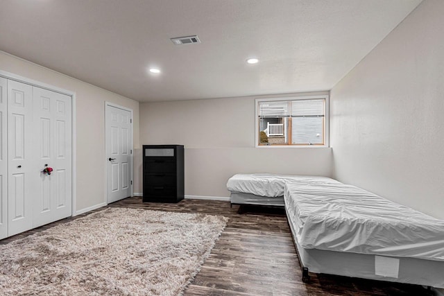 bedroom with baseboards, visible vents, dark wood finished floors, and recessed lighting