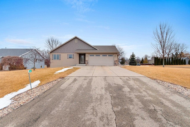 view of front of house featuring an attached garage, a front lawn, and concrete driveway