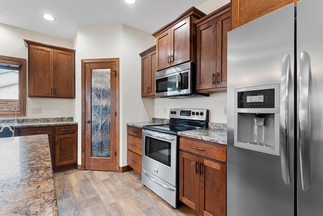 kitchen featuring light wood-style flooring, recessed lighting, stainless steel appliances, a sink, and plenty of natural light