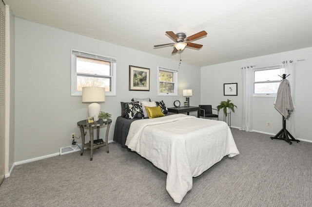 carpeted bedroom with visible vents, baseboards, and a ceiling fan