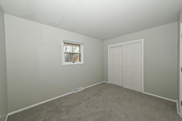 unfurnished bedroom featuring a closet, visible vents, baseboards, and carpet