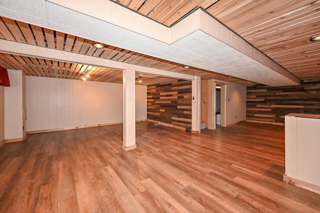 finished below grade area featuring wooden walls and wood finished floors