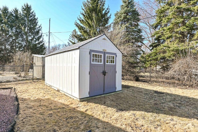 view of shed featuring fence