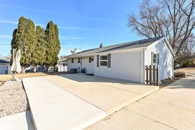 ranch-style home featuring central AC unit, fence, and driveway