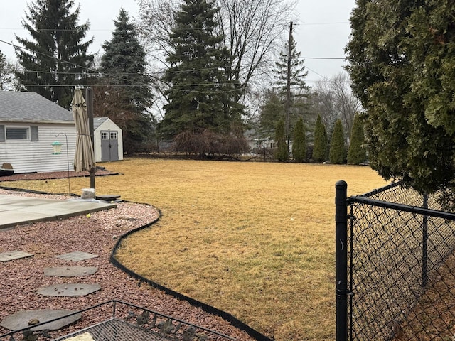 view of yard with a fenced backyard, a storage unit, and an outdoor structure