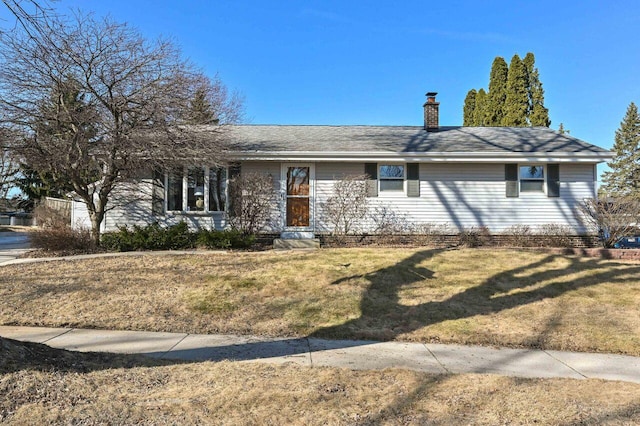 single story home with a chimney and a front yard