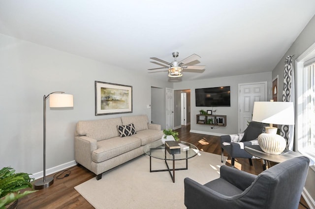 living room with wood finished floors, baseboards, and a healthy amount of sunlight