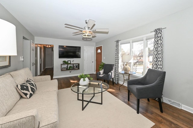 living room featuring dark wood finished floors, baseboards, visible vents, and ceiling fan