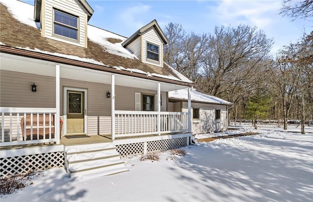 view of front of property with a porch and roof with shingles