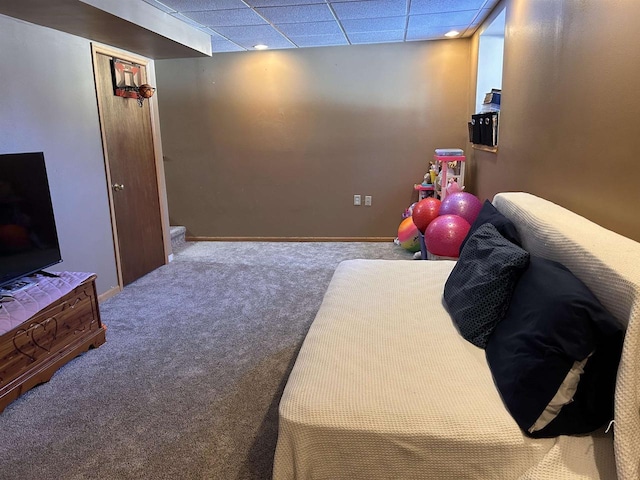 bedroom featuring a drop ceiling, carpet flooring, and baseboards